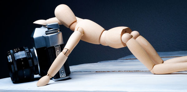 Close up of camera with figurine on table