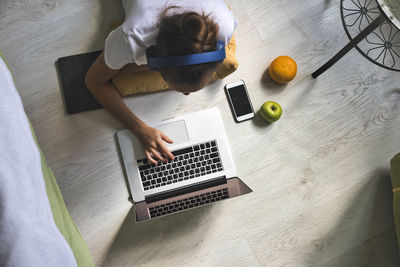 Young woman lying at the window at home with laptop