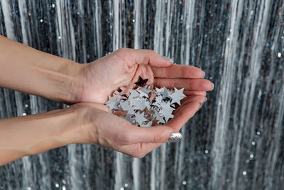 Girl holding in his hands the silver stars sequins