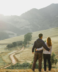 Rear view of couple walking on mountain