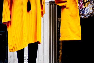 Close-up of yellow clothes hanging on window