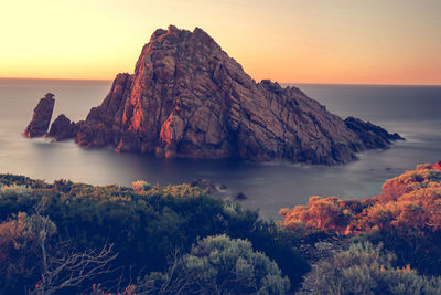 Scenic view of rock formation in sea against clear sky