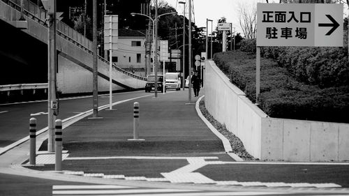 Road by building in city against sky