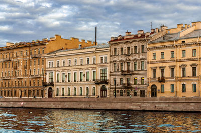 View of buildings in city against cloudy sky