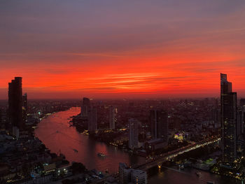 High angle view of city lit up at sunset