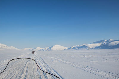 Scenic view of snowcapped mountains against clear blue sky