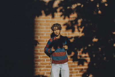 Full length of boy standing against wall