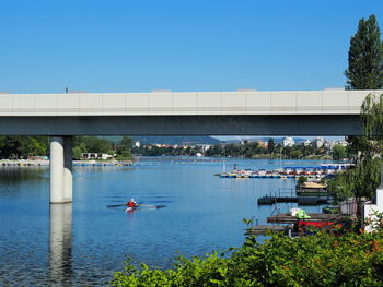 Bridge over river against clear blue sky