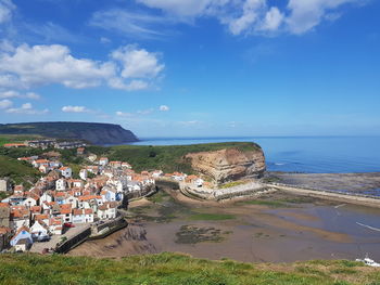 High angle view of townscape by sea against sky