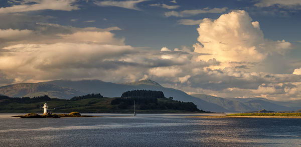 Scenic view of sea and mountains against sky