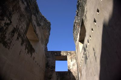 Low angle view of old building against clear blue sky