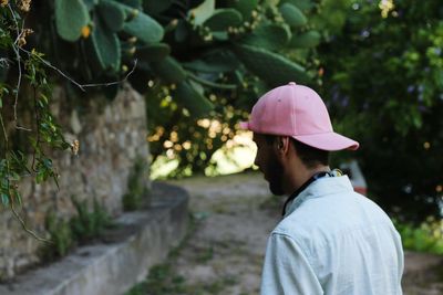 Rear view of man standing amidst plants