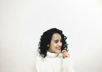 Portrait of young woman against white background