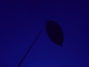 Low angle view of silhouette leaf against blue sky