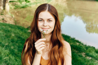 Portrait of young woman with eyes closed against plants