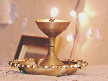 Close-up of illuminated lamp on table