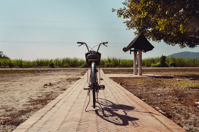 Bicycle on field against clear sky