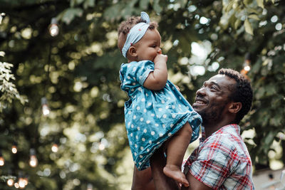 Father with daughter against trees