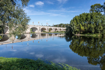 Arch bridge over river against sky