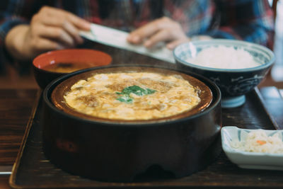 Midsection of man holding coffee on table