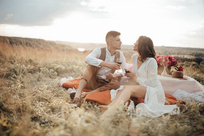 Rear view of couple sitting on rock