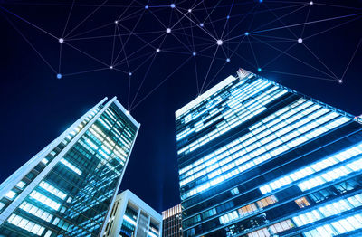 Low angle view of modern buildings against sky at night