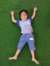 High angle view of boy lying on grass