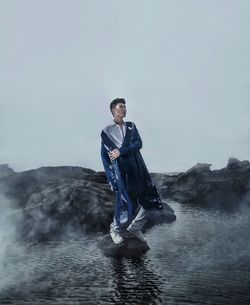 Portrait of young man in sea against sky