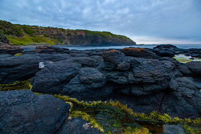 Scenic view of rocks on beach against sky