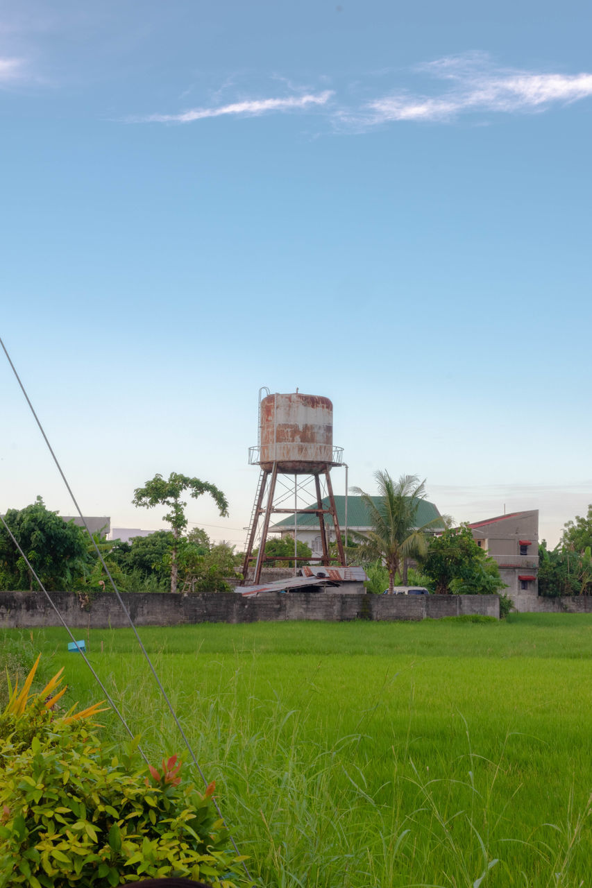 WATER TOWER ON FIELD AGAINST SKY