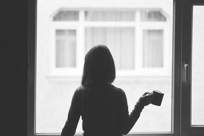 Woman looking through window