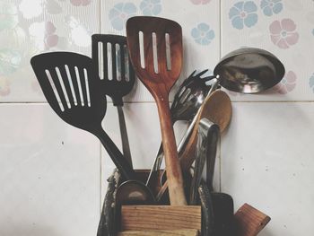 Close-up of variation spatulas in container mounted on wall