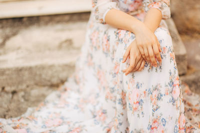 Midsection of woman sitting outdoors