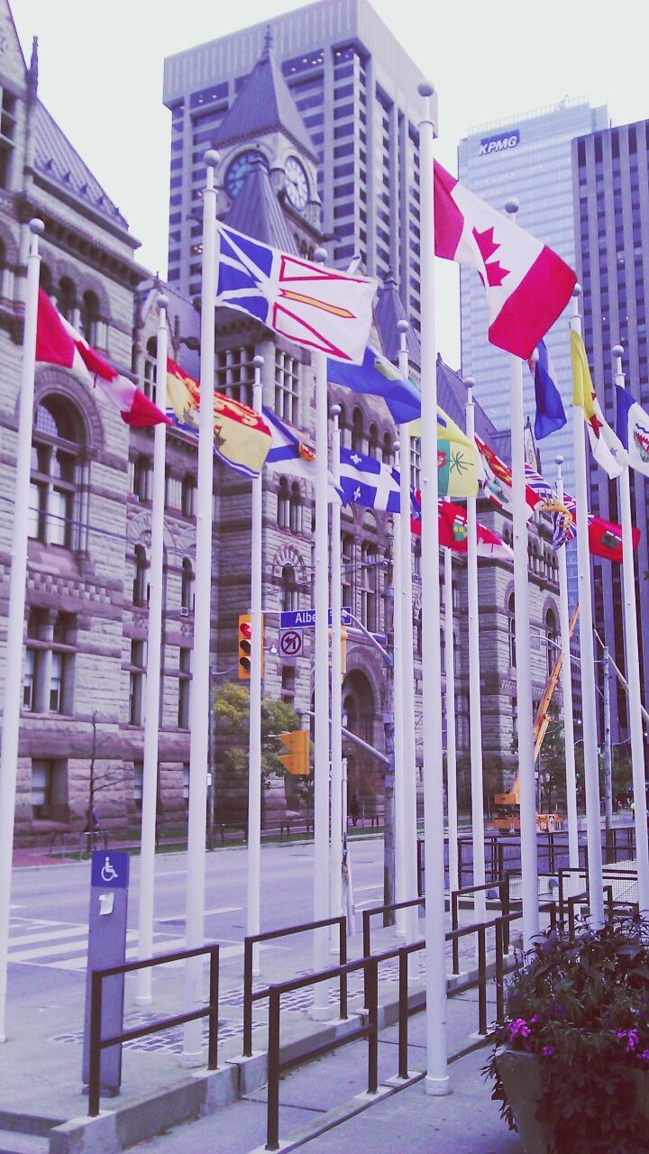 building exterior, architecture, built structure, city, building, low angle view, window, residential building, day, modern, outdoors, flag, exterior, clear sky, balcony, sky, residential structure, no people, facade, western script