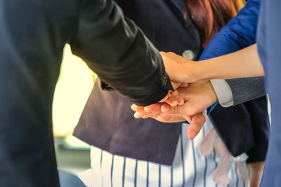 Midsection of couple holding hands