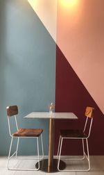 Empty chairs and table against wall at home