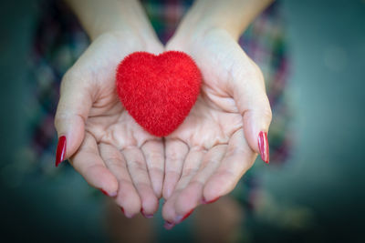 Close-up of woman holding red heart
