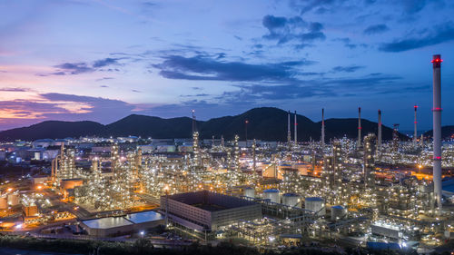 Aerial view oil and gas tank with oil refinery background at night, glitter lighting petrochemical.