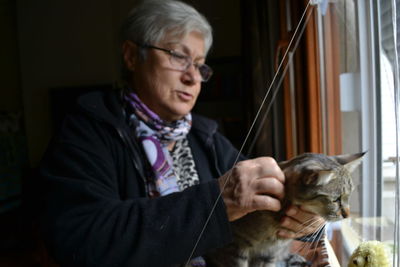 Close-up of woman holding cat sitting on floor