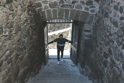 Rear view of woman standing on wall