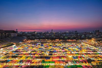 Aerial view of illuminated colorful night market in city against sky