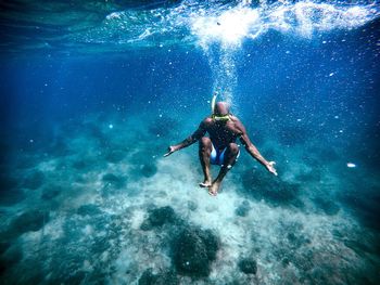 Full length of shirtless man snorkeling in sea