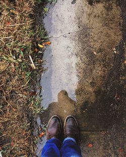 Low section of man standing on puddle