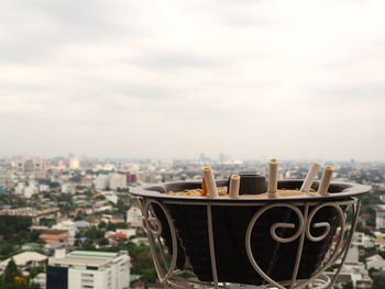 Close-up of drink on building against sky