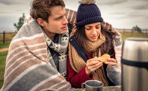 Young woman with man having muffin