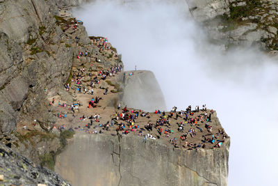 People on rock against sky