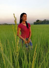 Young woman standing in wheat field