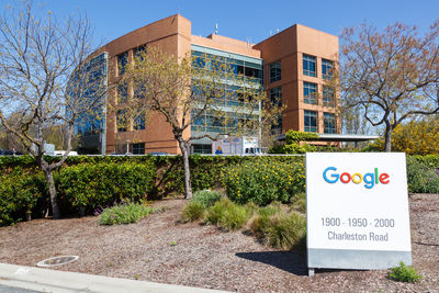 Information sign by building against clear sky