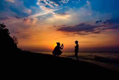 Silhouette of man in sea at sunset