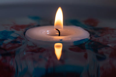 Close-up of lit candle in the dark